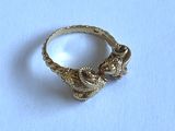 an image of a gold ring on a white surface