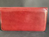 a red leather wallet with a zipper closure