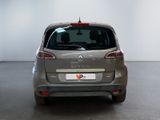 the rear of a silver car in a room with a white wall