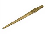 a gold colored metal spoon with a flower design on it