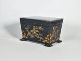 une image représentant une boîte noire et dorée ornée de fleurs