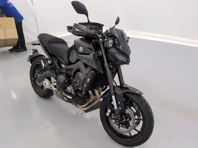 une moto noire garée dans une pièce avec une boîte