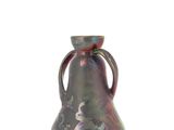 a small vase with a handle on a white surface