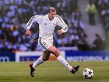 un homme qui tape dans un ballon de foot sur le terrain