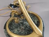 brass and marble lamp with a bird ' s nest on top of it