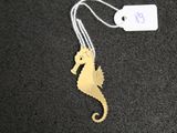 a gold seahorse that is hanging from a string