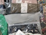 many bags of clothes that are sitting on top of each other