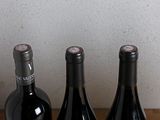 three bottles of wine sitting on a table next to each other