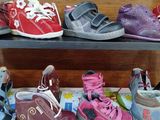 many pairs of children ' s shoes on a shelf
