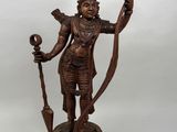 a bronze statue of a hindu man holding a staff