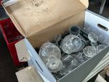 a box full of empty wine glasses sitting on the floor