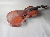 an old violin sitting on top of a white sheet on a table