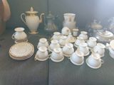 beaucoup de vaisselle blanche et dorée sur la table