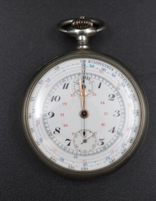 a close up of a pocket watch on a black surface