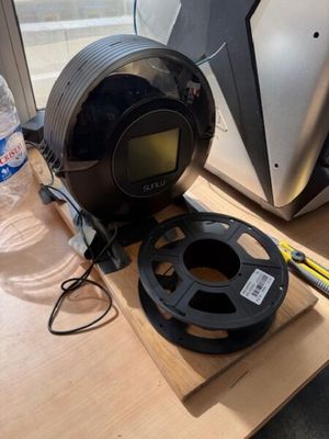 une horloge posée sur une table à côté d'une bouteille d'eau