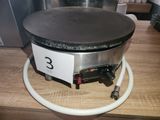 a black and silver crepe maker on a wooden table