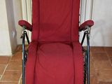 a red reclining chair that is sitting on a tile floor