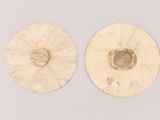 two white discs with holes in them on a white surface