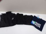 une pile de t-shirts posée sur une table, à côté d'une bouteille d'eau