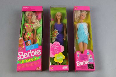 three barbie dolls are in their boxes on a gray surface