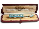 a blue and white beaded broocher in a case