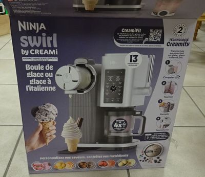 someone is holding up a box of ice cream with a scoop of ice cream in it