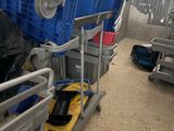 a man standing next to a cart filled with blue crates