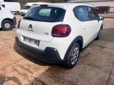 a small white car that is parked in a parking lot