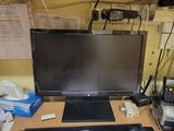 a desk with a monitor, mouse, and other items on it