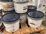 plusieurs seaux de peinture posés sur une palette dans un entrepôt