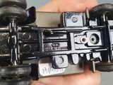 a person holding a cell phone with a toy racing car on it