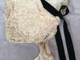 bonnet en dentelle couleur crème avec un ruban noir sur fond blanc