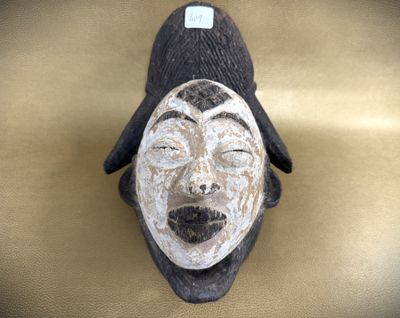a wooden mask with a black hat on top of it