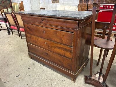 a wooden dresser with a marble top in a room