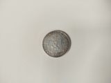 a close up of a silver coin on a white surface