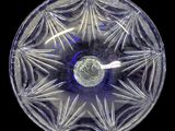 an image of a clear glass bowl with a blue center on a black background