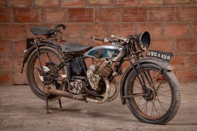 a old motorcycle that is parked in front of a brick wall