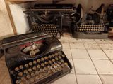 an old typewriter sitting on a tile floor in a room