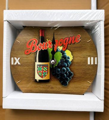 une horloge en bois sur laquelle sont représentés une bouteille de vin et des raisins