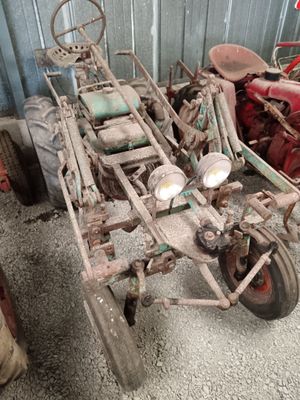 an old tractor with a trailer attached to it in a garage