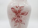 un vase blanc orné d'une fleur rouge