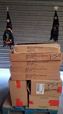 des cartons empilés les uns sur les autres sur une palette devant la porte d'un garage