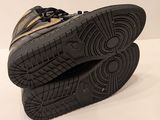 pair of black and gold sneakers sitting on top of each other