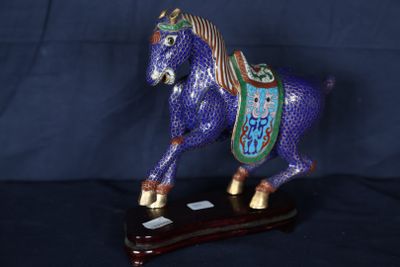 une figurine représentant un cheval bleu posée sur un socle en bois
