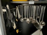 un gros plan sur un ensemble d'ustensiles de cuisine rangés dans un placard