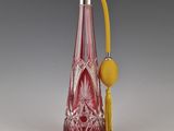 une bouteille en verre rouge avec une poignée jaune et une boule jaune