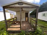 une petite maison blanche avec un porche et un banc