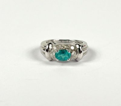 a close up of a ring with a green stone on it