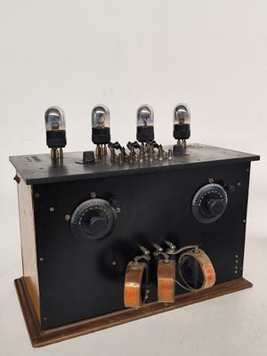 un gros plan d'un appareil électronique noir posé sur un socle en bois