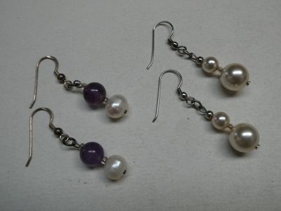 des perles violettes et blanches et des boucles d'oreilles en argent sur un fond blanc